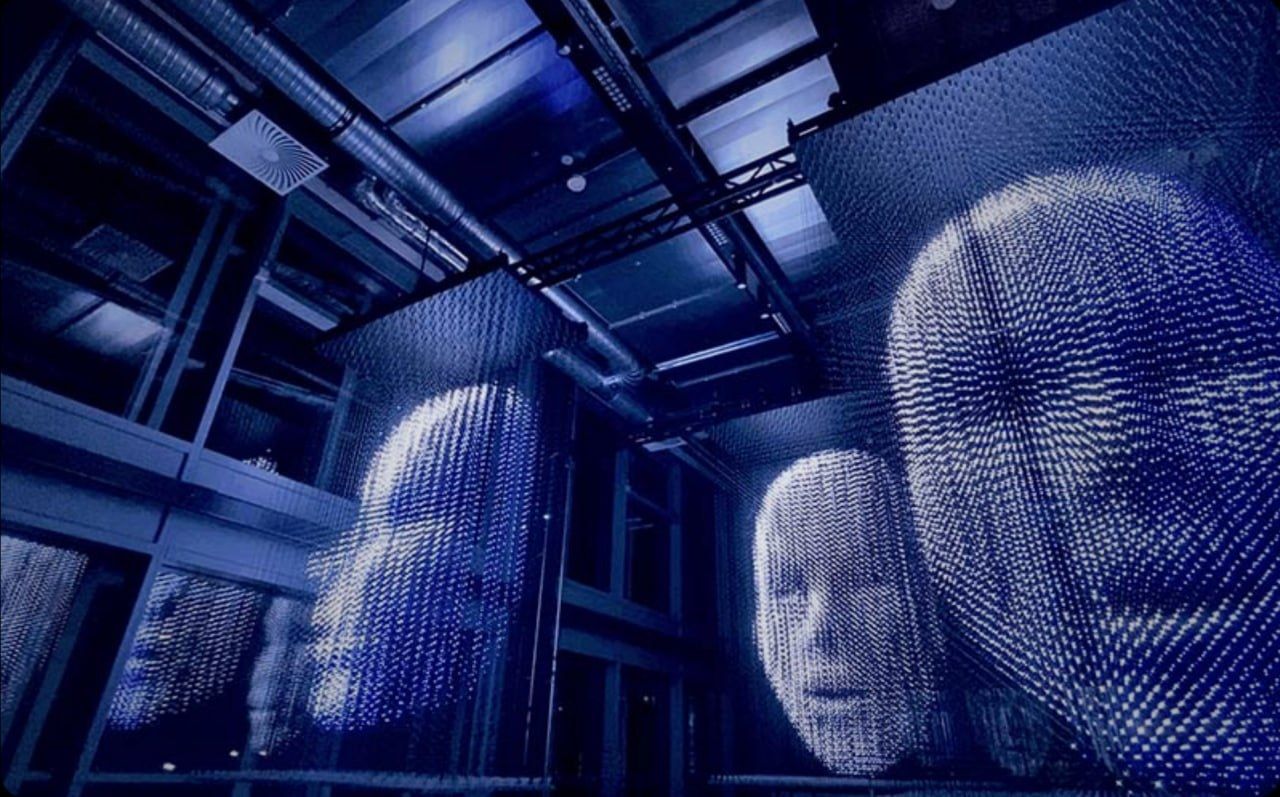 A volumetric LED installation: three-dimensional faces made of light points suspended in a dark hall